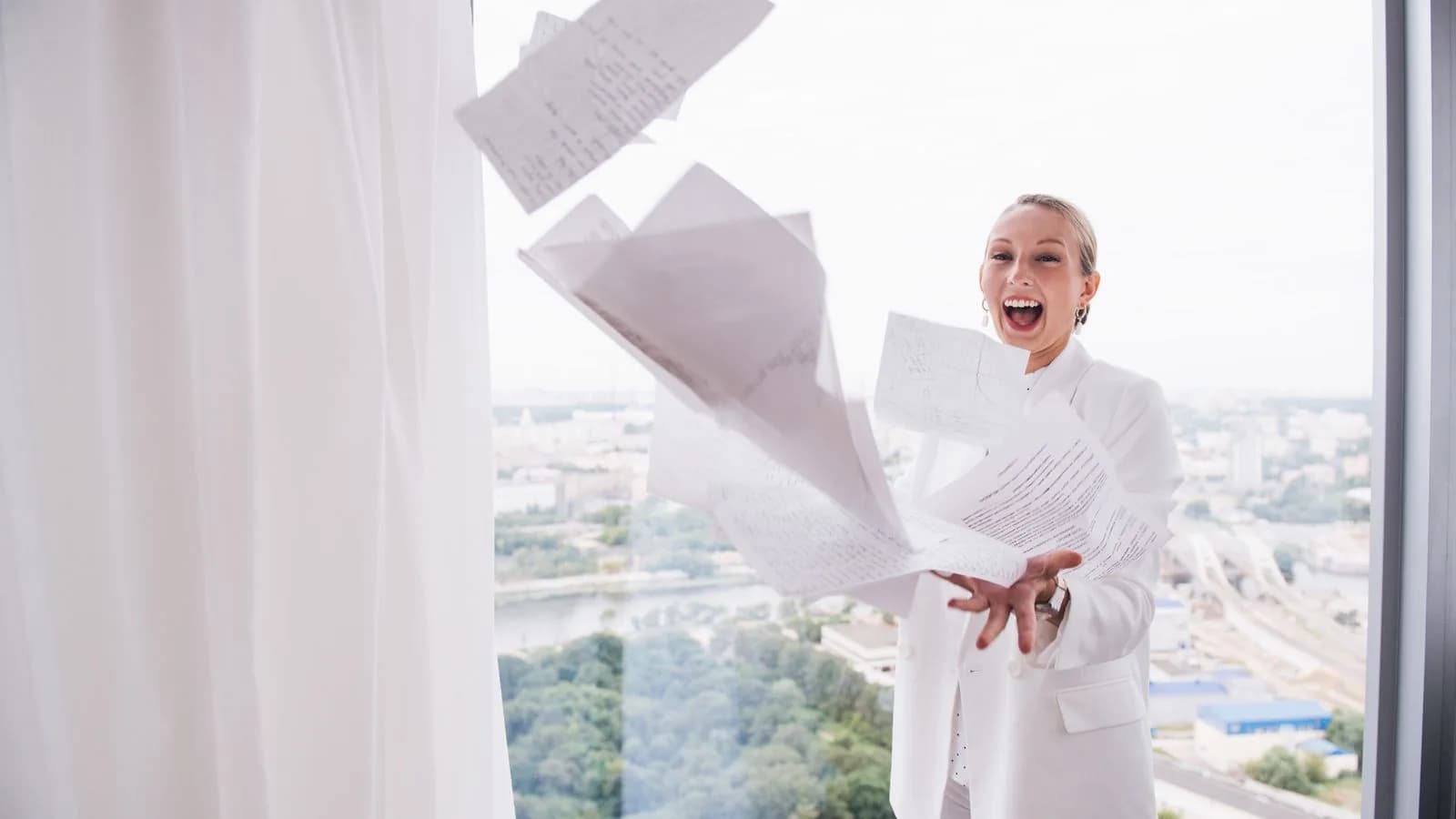 Confident professional woman celebrating CFA exam success in a bright office